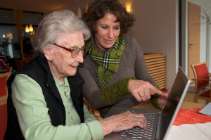 älter Dame mit Betreuerin am Laptop