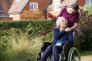Daughter Pushing Senior Mother In Wheelchair