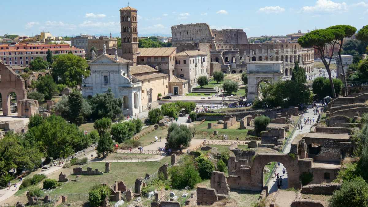 Blick von oben auf die Runinen des Forum Romanum in Rom mit Kirche im Hintergrund